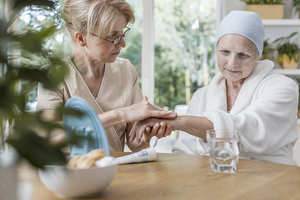 Travailleur de la santé tenant la main d’un patient en phase terminale